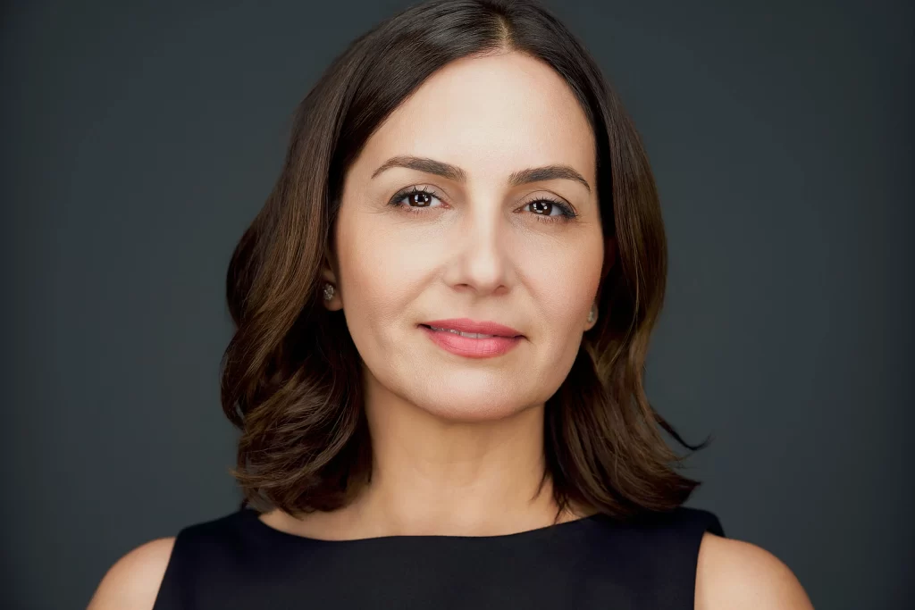 Professional headshot of Marjan in a black sleeveless top against a dark background in San Francisco.
