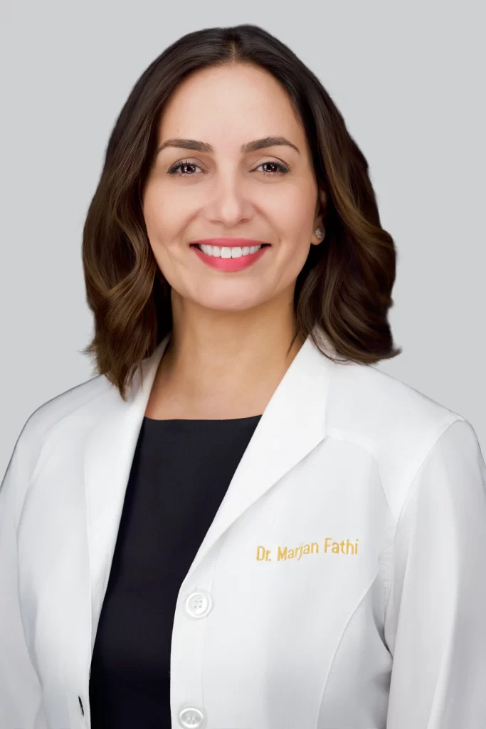 Dr. Marjan Fathi wearing a white coat against a light gray background
