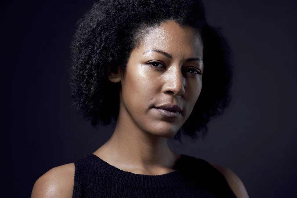 modeling headshot of June with a direct expression against a dark studio background.