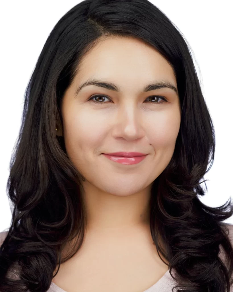 Karisma with a soft smile, wearing a pale mauve top against a white background.